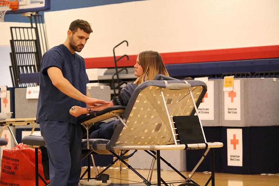 Preparing herself to getting her blood drawn, sophomore MAganne Morrand looks away from the nurse who is searching for a vien in her arm.