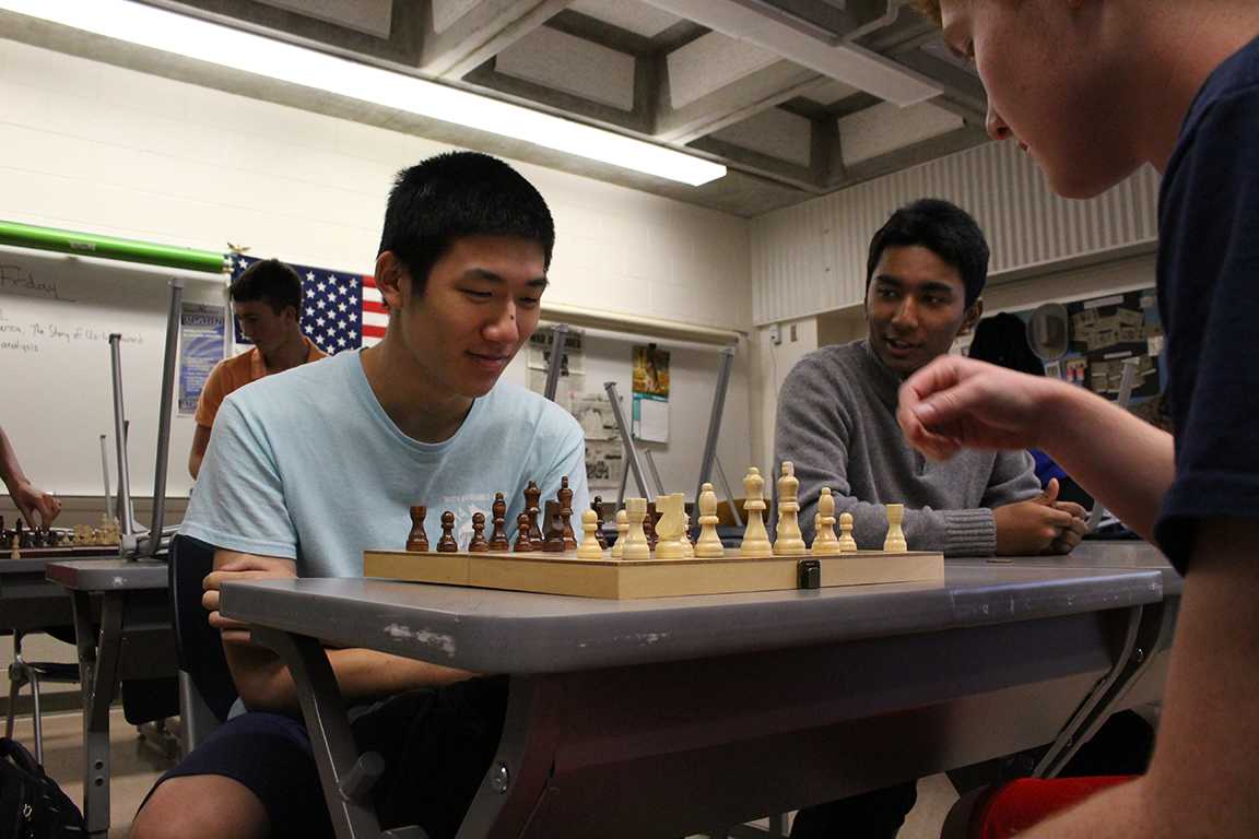 Chess Club members  seniors Tony Liu and Tim Toy play a game of chess during their second meeting as senior Saubhagya Shreshta spectates.